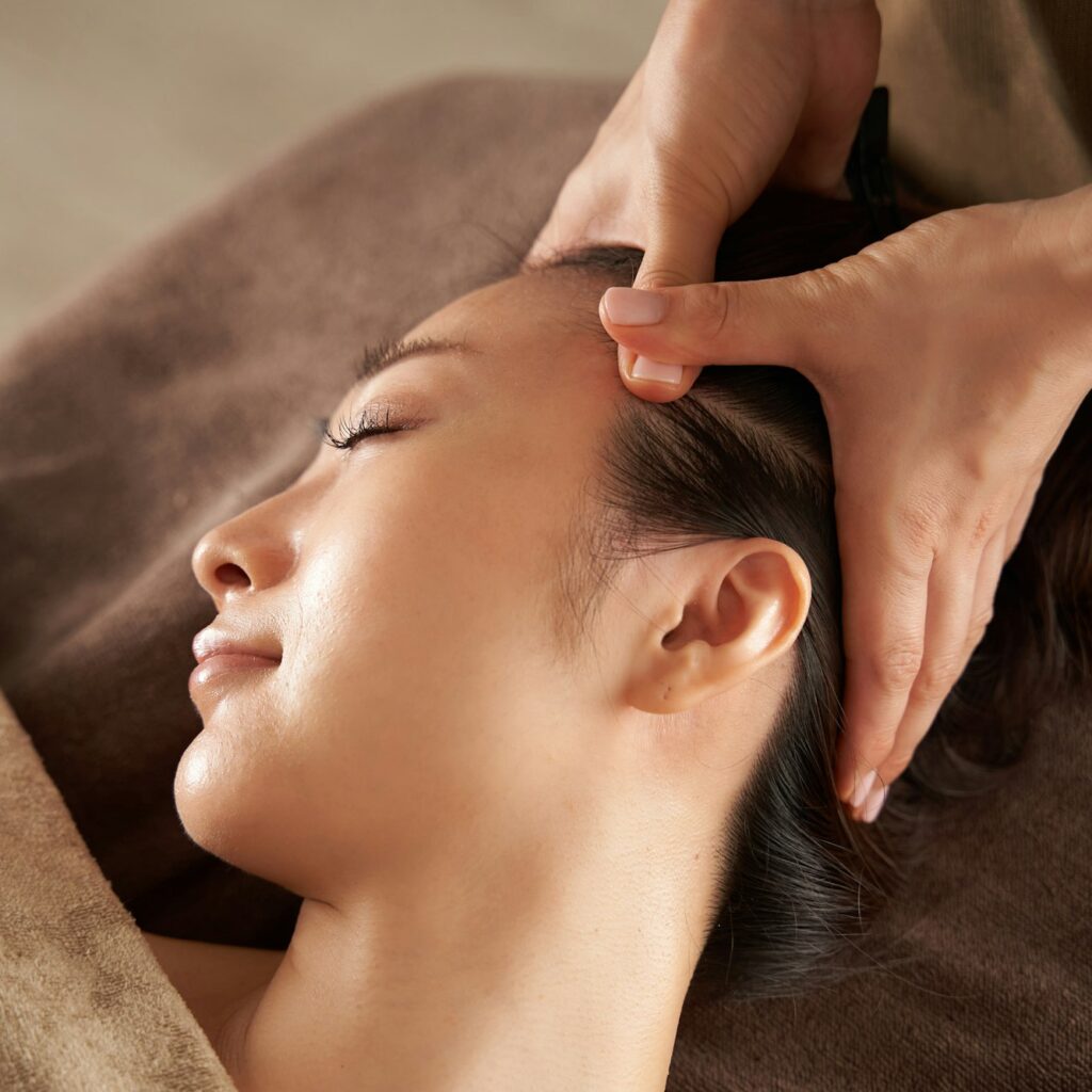 Japanese woman receiving a facial massage at an aesthetic salon